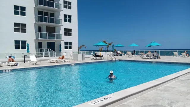 a view of pool with outdoor seating and yard