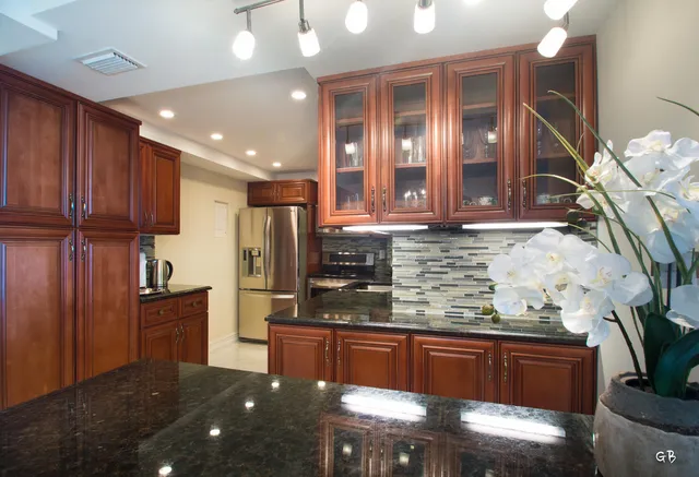 a kitchen with stainless steel appliances granite countertop wooden cabinets and a granite counter tops