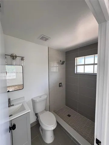 a bathroom with a shower a toilet and sink