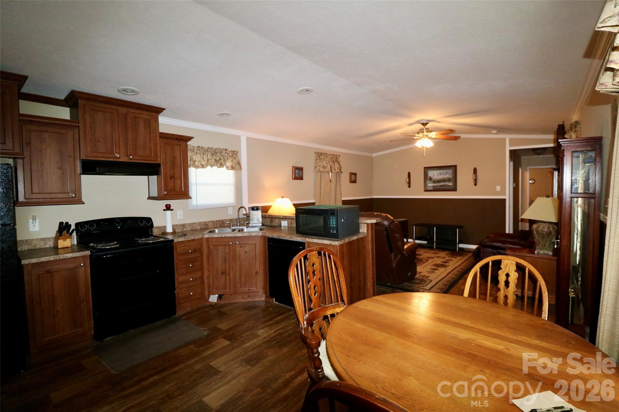 116 Sienna Court Grover, NC 28073 - Photo 4 of 19 a kitchen with stainless steel appliances granite countertop a stove top oven a sink a dining table and chairs with wooden floor