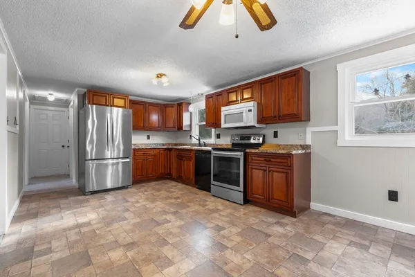 a kitchen with stainless steel appliances granite countertop a refrigerator stove and sink