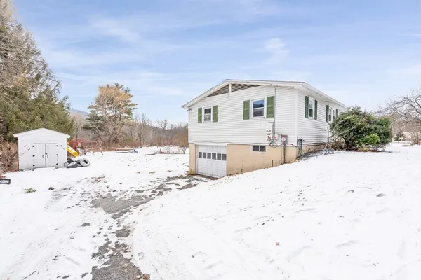 a view of residential houses with snow on the road