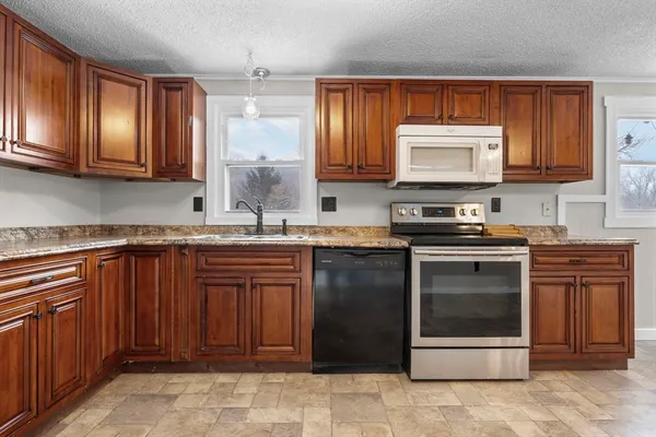 a kitchen with stainless steel appliances granite countertop a stove microwave and sink