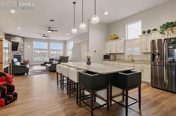a kitchen with stainless steel appliances a dining table chairs stove refrigerator and cabinets