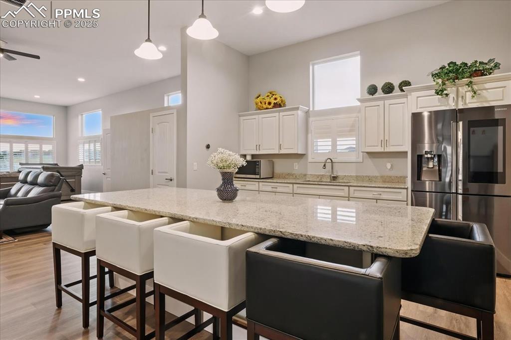 11970 Silver Concho Trail Elbert, CO 80106 - Photo 19 of 44 a kitchen with stainless steel appliances granite countertop a dining table chairs and a refrigerator