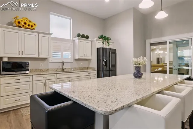 a kitchen with granite countertop kitchen island stainless steel appliances a refrigerator stove and sink