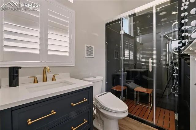 a bathroom with a sink a toilet and shower