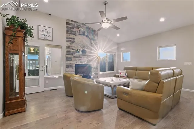 a living room with furniture a large window and a fireplace