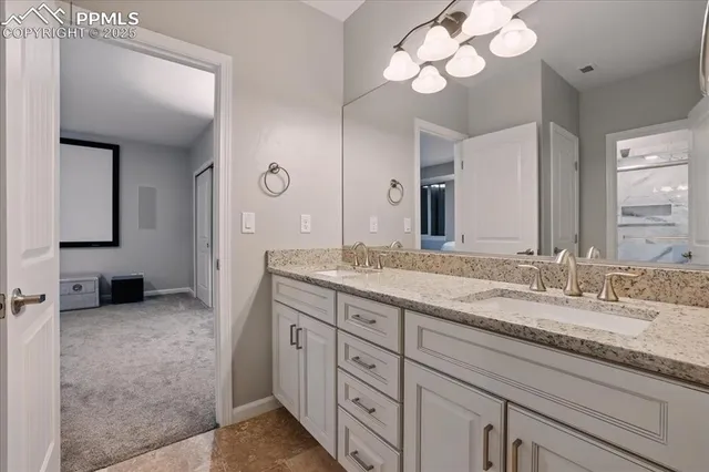 a spacious bathroom with a granite countertop sink a light fixture and a mirror