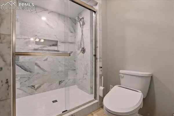 a white toilet next to a bathroom