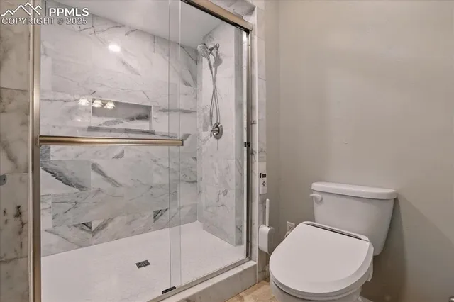 a white toilet next to a bathroom