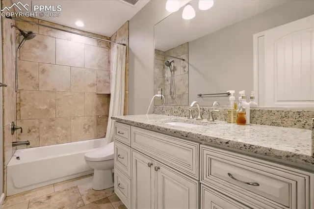 a bathroom with a granite countertop sink a toilet and bathtub