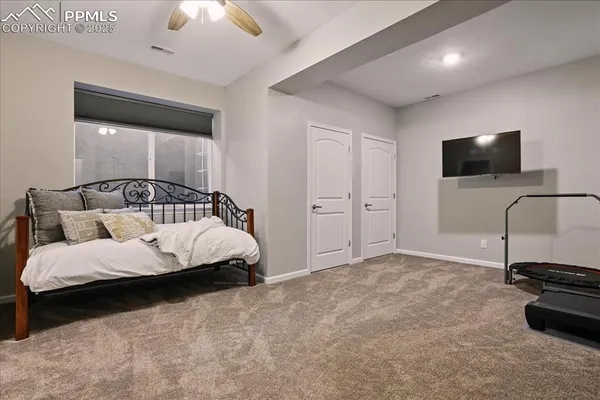 a bedroom with bed and a flat tv screen on dresser