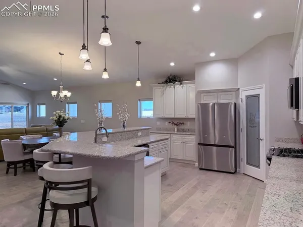 a kitchen with refrigerator and chairs
