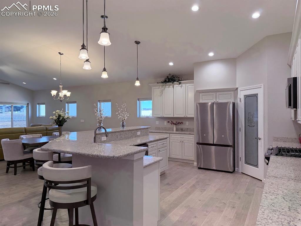 11970 Silver Concho Trail Elbert, CO 80106 - Photo 4 of 44 a kitchen with refrigerator and chairs