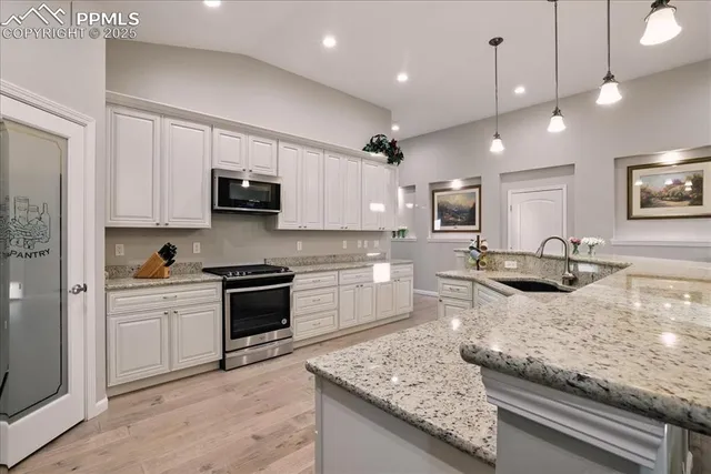 a kitchen with stainless steel appliances granite countertop a sink stove and microwave