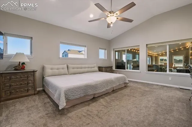 a spacious bedroom with a large bed and a chandelier
