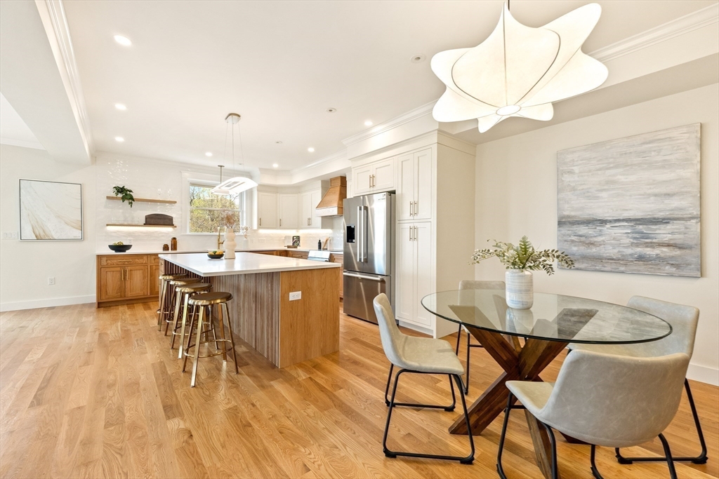 3 Colburn Street, Unit 1 Gloucester, MA 01930 - Photo 15 of 42 a kitchen with kitchen island a dining table chairs stainless steel appliances and cabinets