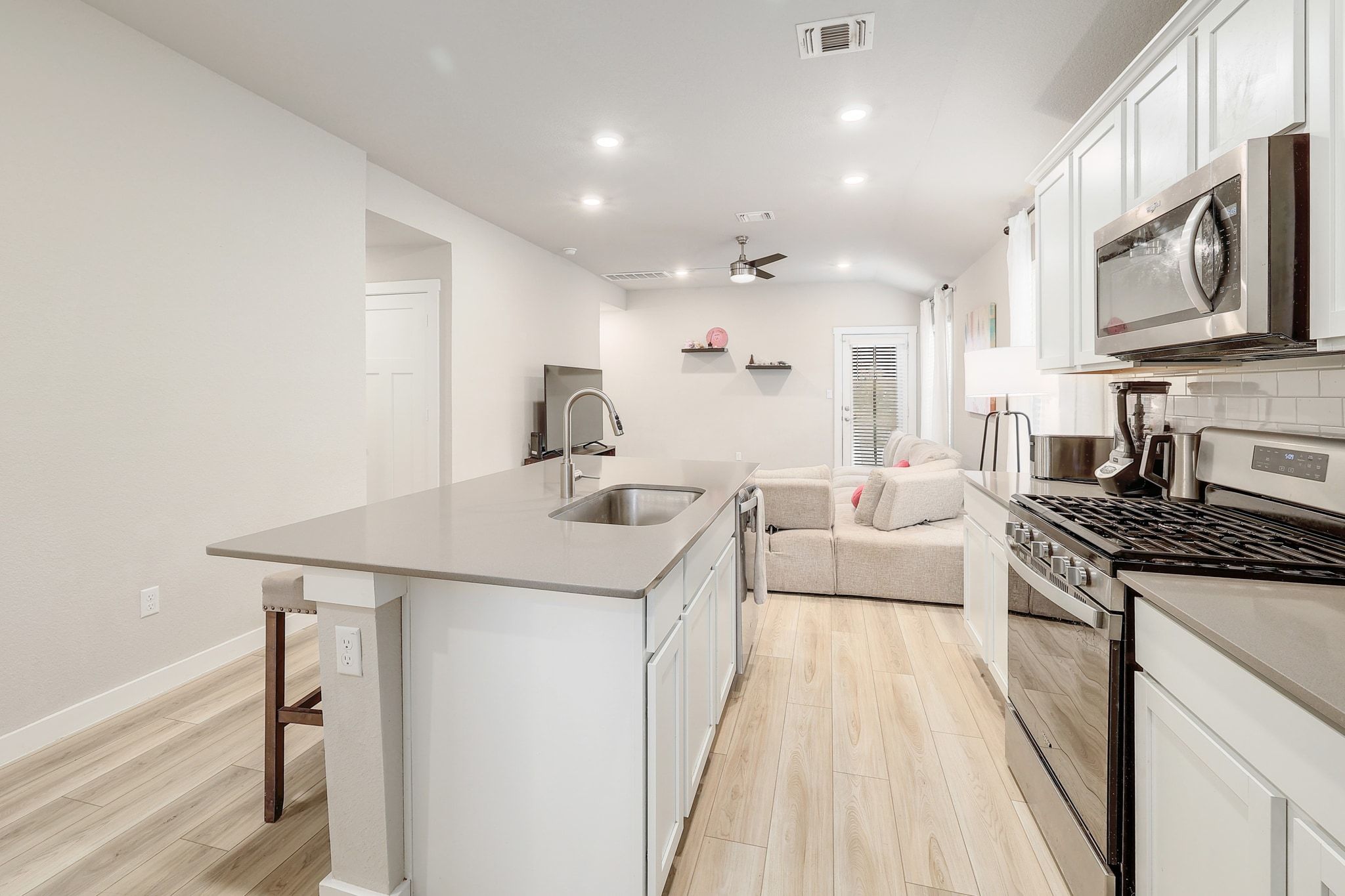 204 Halford Road Georgetown, TX 78633 - Photo 27 of 27 Kitchen with stainless steel appliances, open floor plan, white cabinetry, a kitchen island with sink, and a kitchen breakfast bar