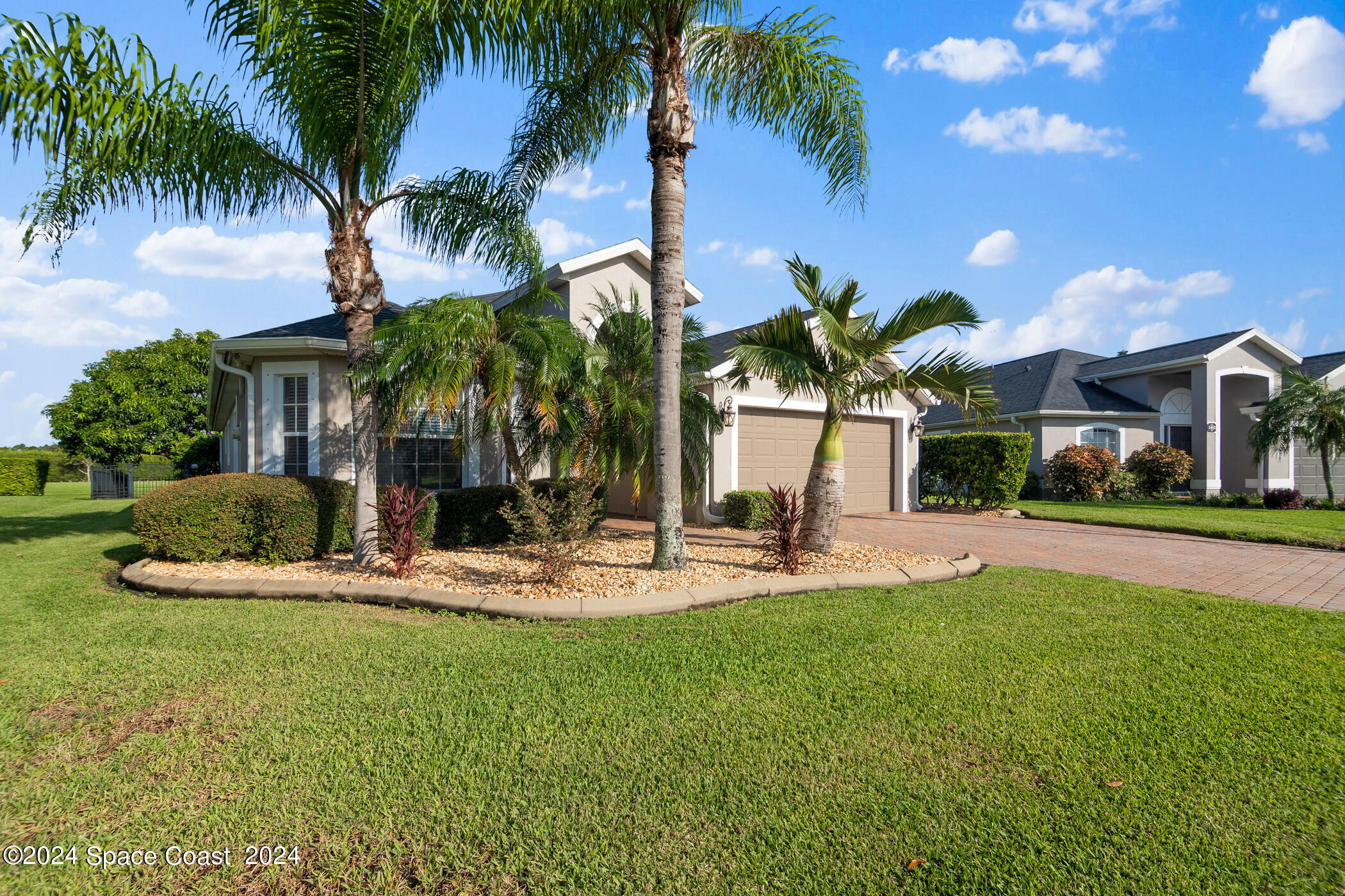 3412 Siderwheel Drive Rockledge, FL 32955 - Photo 4 of 39 a view of a white house with a yard and palm trees