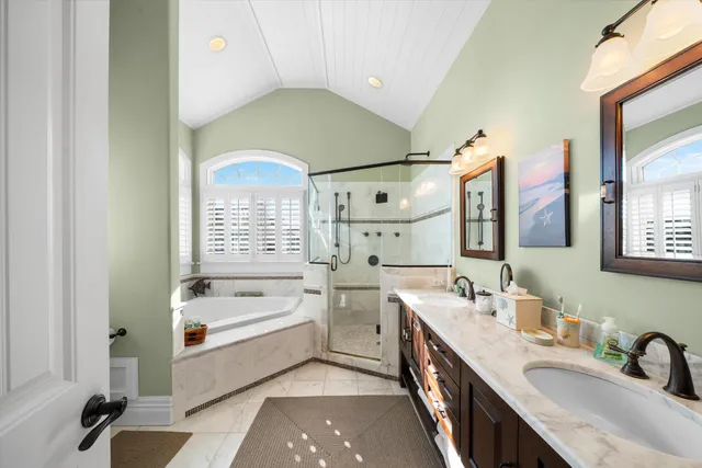 a bathroom with a double vanity sink a mirror and a bathtub