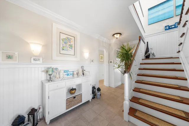 a view of hallway with window and wooden floor