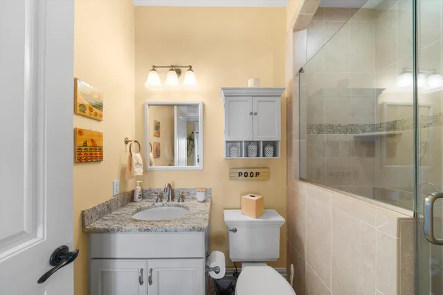 a bathroom with a granite countertop sink toilet and shower