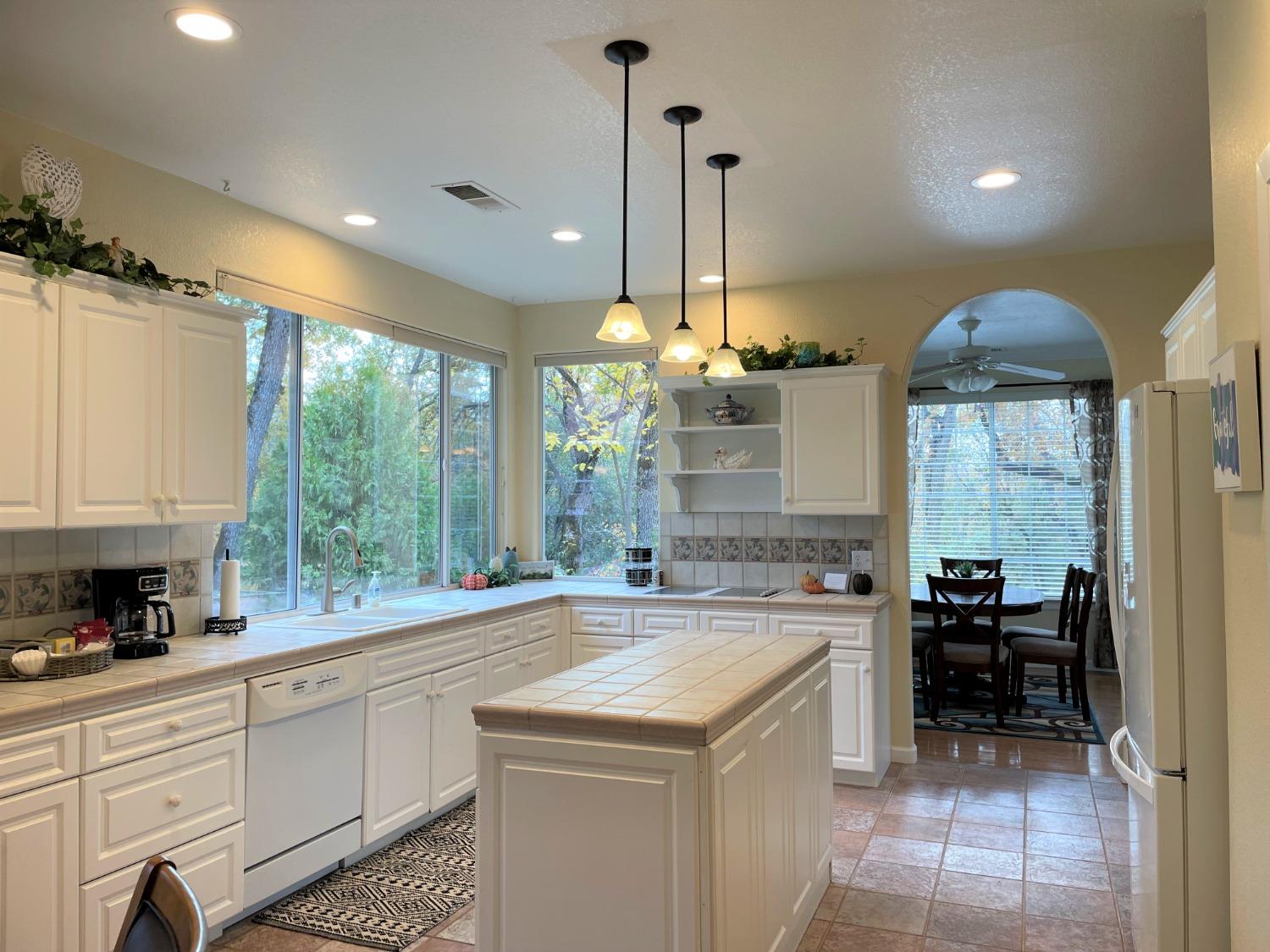 34811 Wintergreen Loop North Fork, CA 93643 - Photo 7 of 18 a kitchen with a stove a sink a kitchen island with windows and chairs