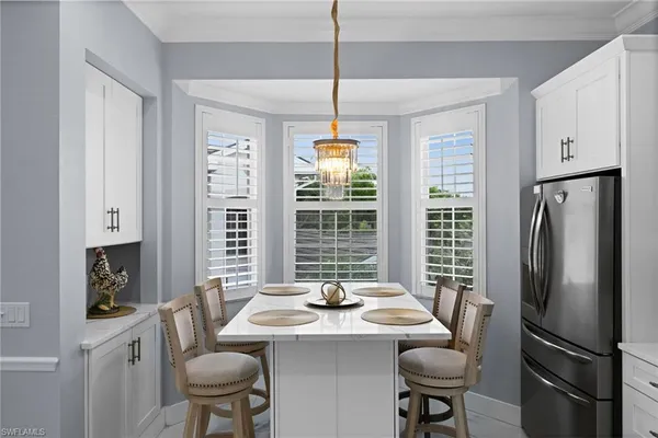 a dining room with furniture a chandelier and window
