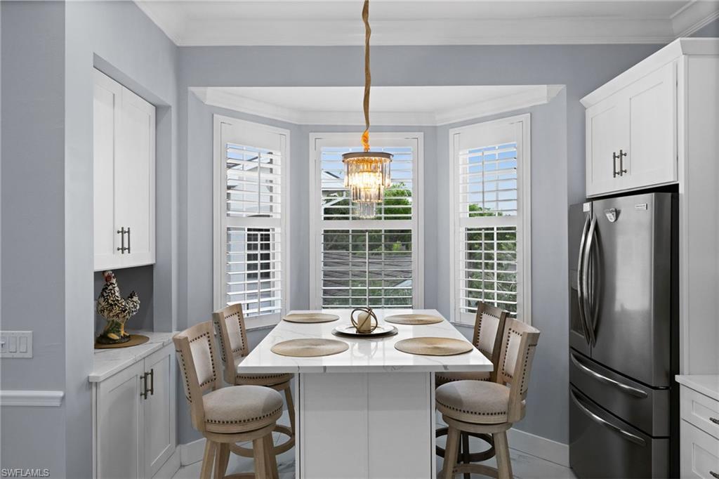 5010 Marina Cove Drive, Unit 4 Naples, FL 34112 - Photo 11 of 42 a dining room with furniture a chandelier and window