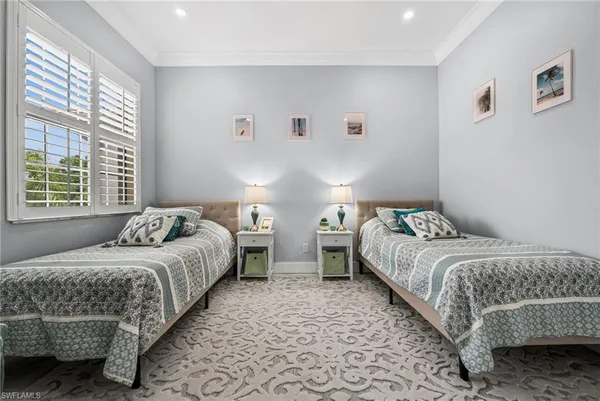 a bedroom with two beds and a window