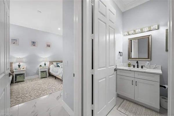 a en suite bathroom with a granite countertop sink mirror and toilet