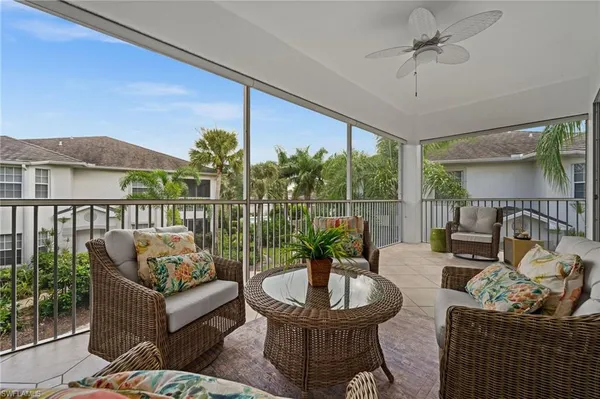 a living room with patio furniture and a potted plant