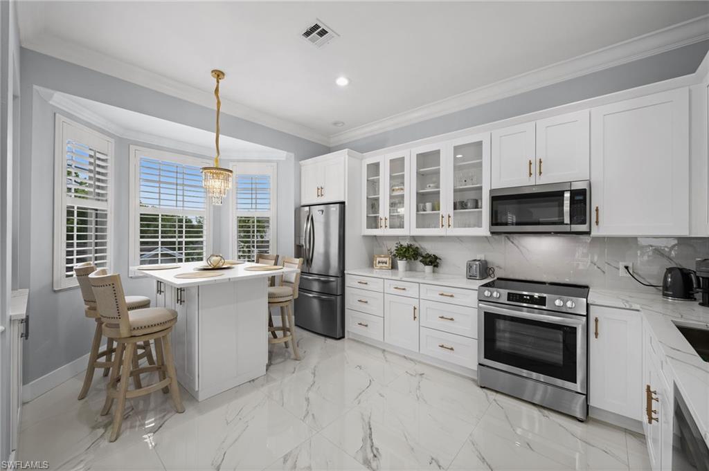 5010 Marina Cove Drive, Unit 4 Naples, FL 34112 - Photo 9 of 42 a kitchen with a stove a sink and microwave