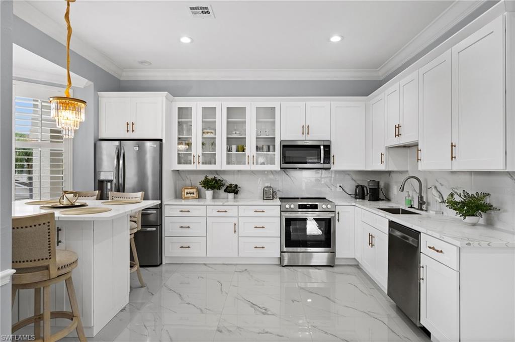 5010 Marina Cove Drive, Unit 4 Naples, FL 34112 - Photo 10 of 42 a kitchen with a stove top oven sink and cabinets