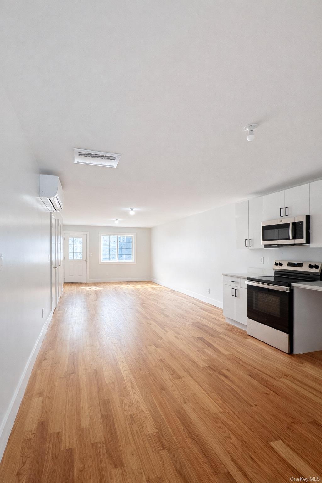 1140 Highway 52, Unit 5 Loch Sheldrake, NY 12759 - Photo 6 of 22 a view of a kitchen with wooden floor and electronic appliances