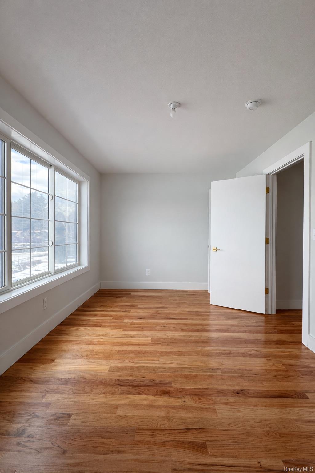 1140 Highway 52, Unit 5 Loch Sheldrake, NY 12759 - Photo 7 of 22 a view of an empty room with wooden floor and a window