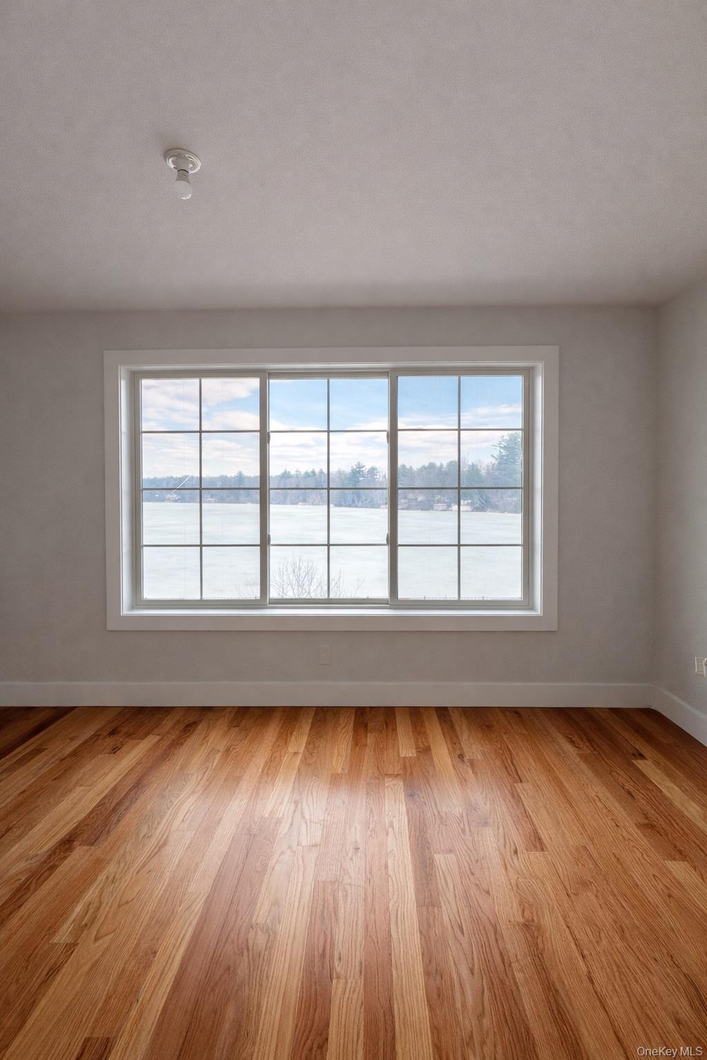 1140 Highway 52, Unit 5 Loch Sheldrake, NY 12759 - Photo 8 of 22 wooden floor in an empty room with a window
