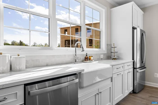 a kitchen with white cabinets and appliances
