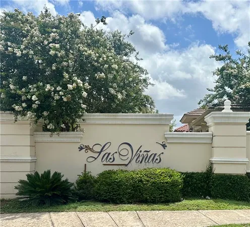 a view of a sign board with buildings in the background