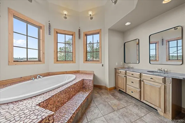 a spacious bathroom with a granite countertop tub sink and mirror