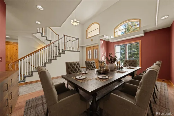 a view of a dining room with furniture a chandelier and wooden floor
