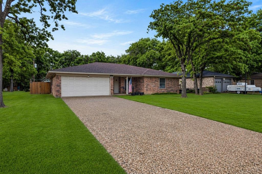Single story home featuring a garage, brick siding, and concrete driveway