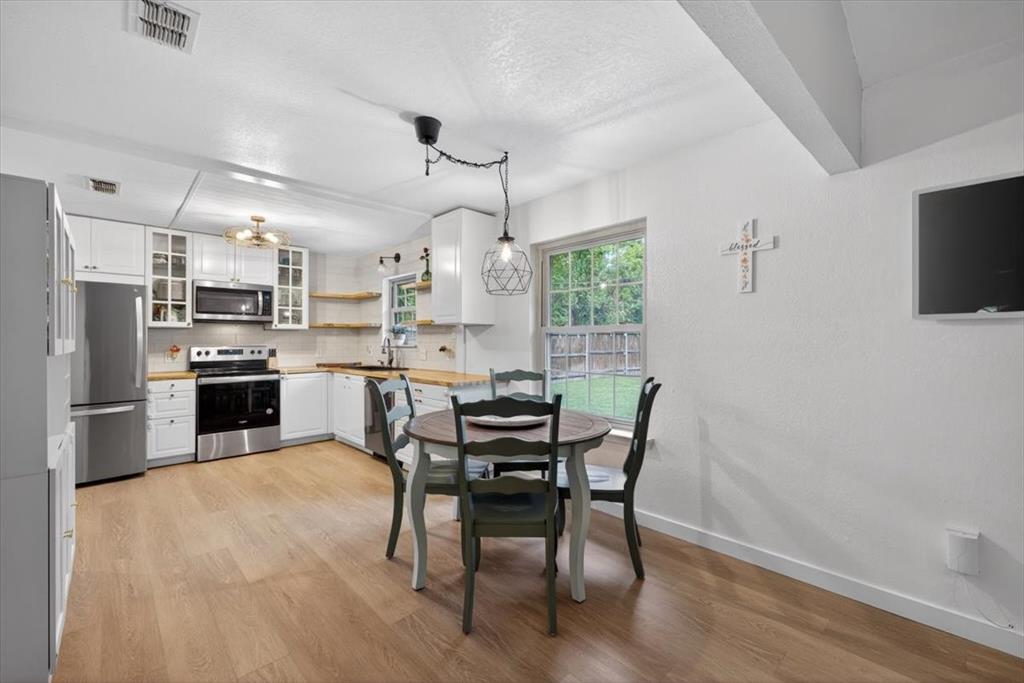 405 Pecan Street Azle, TX 76020 - Photo 11 of 33 Dining space featuring light wood-style floors and a textured ceiling