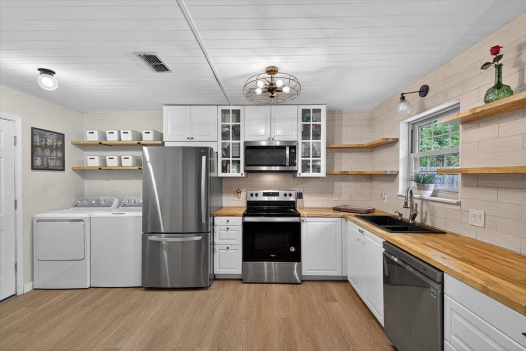 405 Pecan Street Azle, TX 76020 - Photo 14 of 33 Kitchen with open shelves, stainless steel appliances, white cabinetry, and tasteful backsplash