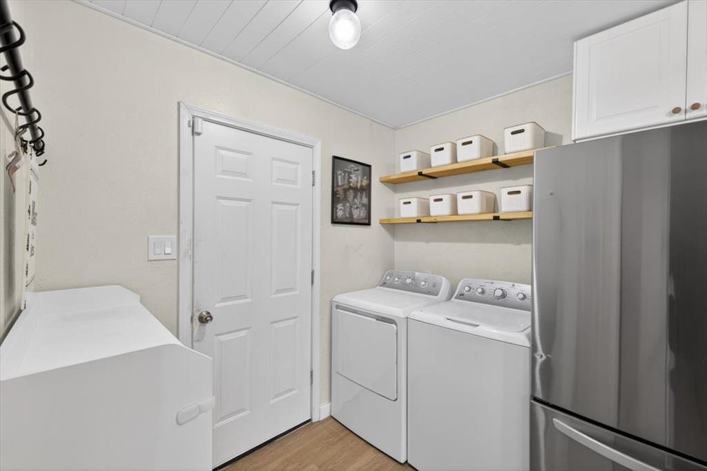 405 Pecan Street Azle, TX 76020 - Photo 16 of 33 Laundry area featuring washing machine and dryer and light wood-style floors