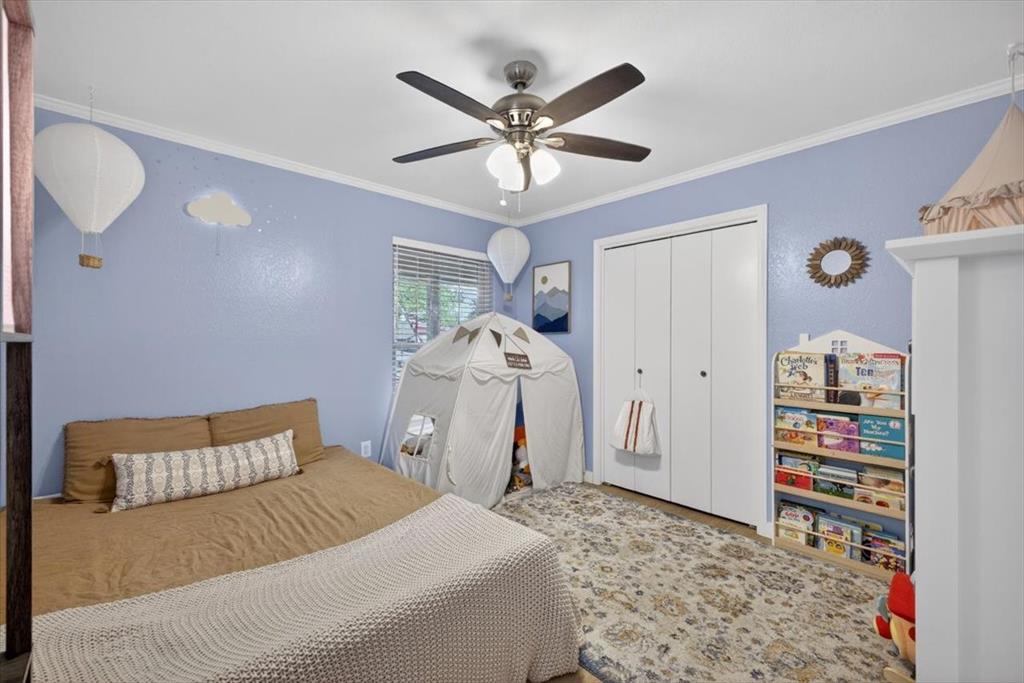 405 Pecan Street Azle, TX 76020 - Photo 21 of 33 Bedroom featuring a closet, ornamental molding, and a ceiling fan