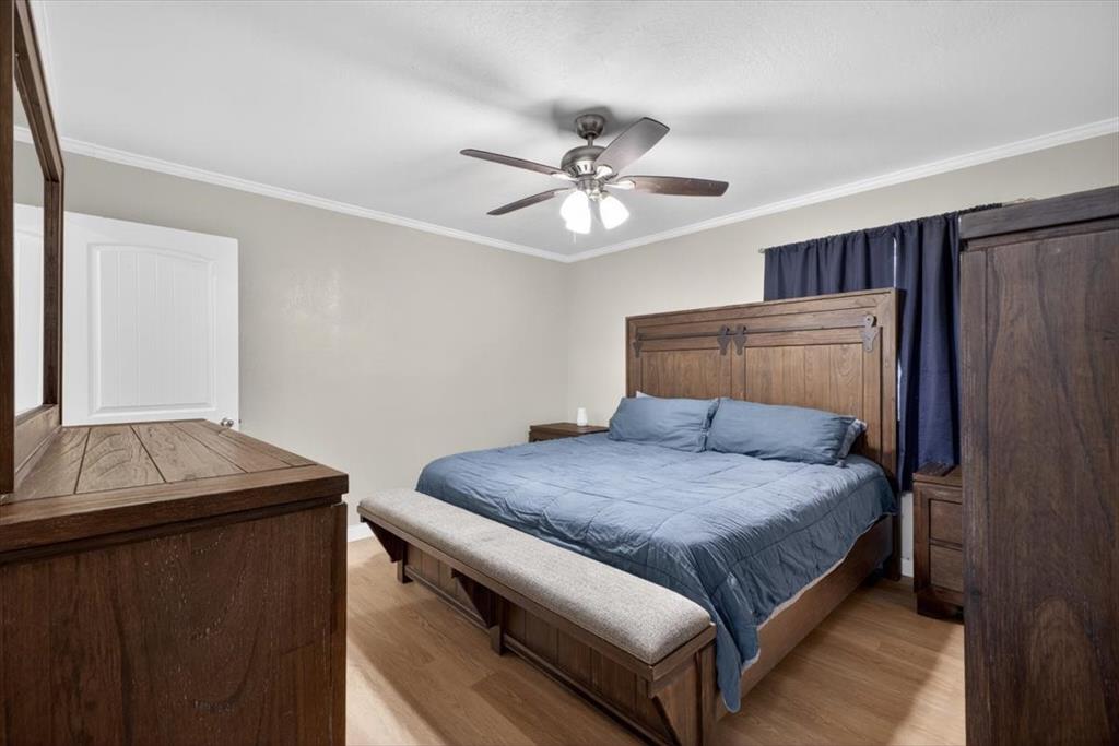 405 Pecan Street Azle, TX 76020 - Photo 22 of 33 Bedroom featuring light wood-style floors, ornamental molding, and a ceiling fan