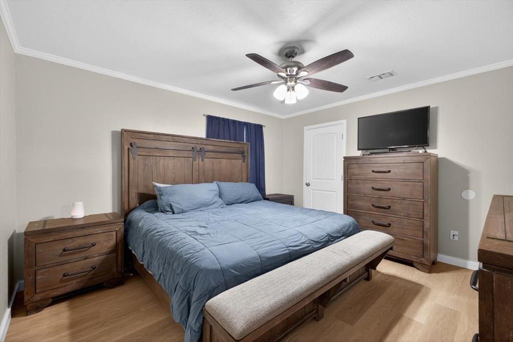 405 Pecan Street Azle, TX 76020 - Photo 24 of 33 Bedroom featuring light wood-style floors, ornamental molding, and ceiling fan