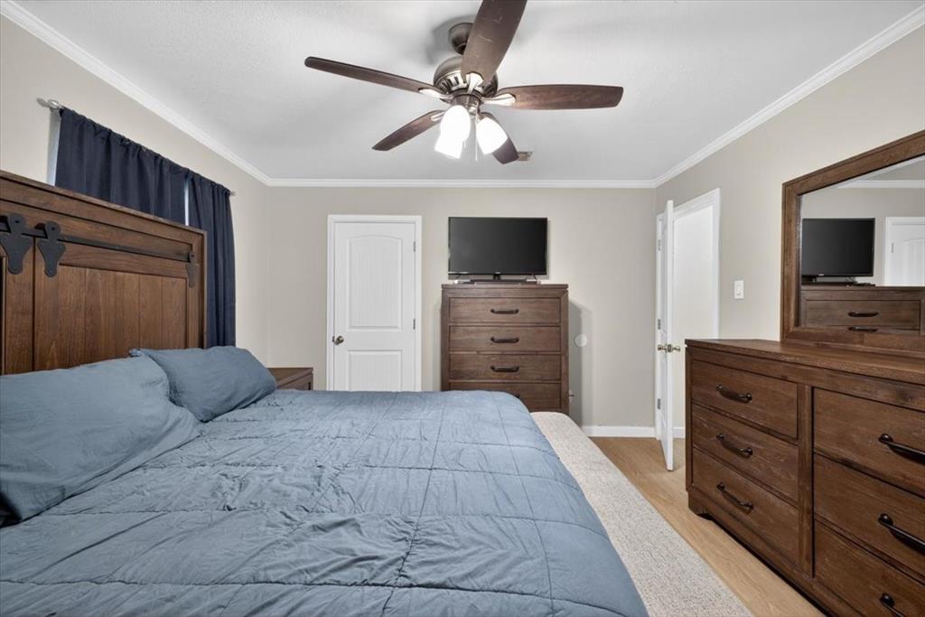 405 Pecan Street Azle, TX 76020 - Photo 26 of 33 Bedroom with crown molding, ceiling fan, and light wood finished floors